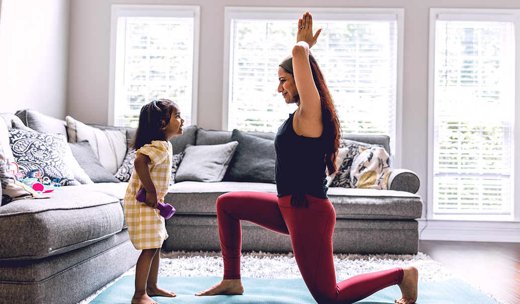 A mother doing yoga and training her child